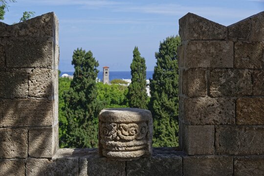 View from a stone wall with battlements of green trees and the distant sea under a blue sky, Grand Master's Palace, Medieval Town of Rhodes, Rhodes Island, Greece