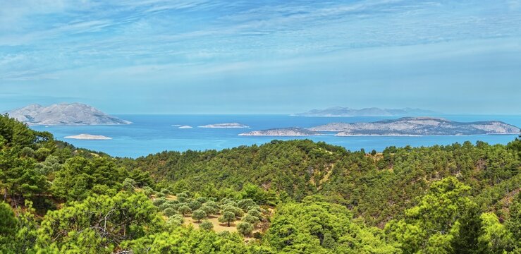 Wide view of a dense forest and the blue sea with islands Chalki and Alimia on the horizon under a clear sky, Ataviros, Rhodes Island, Greece
