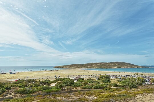 Spacious sandy beach of Prasonisi overlooking the sea and a small island under a blue sky with clouds, Prasonisi, Rhodes Island, Greece