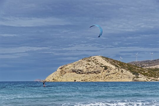 Prasonisi beach with a view of the sea and rocky island with visible kite and wind turbines. Windy coastal landscape, Prasonisi, Rhodes Island, Greece