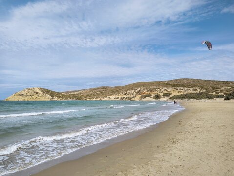 Quiet beach of Prasonisi with gentle waves and a kite in the sky under a slightly cloudy sky, conveys serenity and freedom, Prasonisi, Rhodes Island, Greece