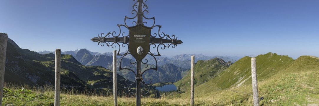 Forged memorial cross for Josef B&ouml;ck, master shepherd of the rear Seealpe, behind it mountain panorama from the Zeigersattel to the Seealpsee, on the left the H&ouml;fats 2259m, in the centre of the picture the Allg&auml;u main ridge with Trettachspitze 2595m, M&auml;delegabel 2645m, Bockkarkopf 2609m and Hochfrottspitze 2649m, Allg&auml;u Alps, Allg&auml;u, Bavaria, Germany