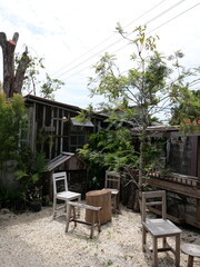 rustic outdoor seating with wooden chairs and table in natural garden courtyard
