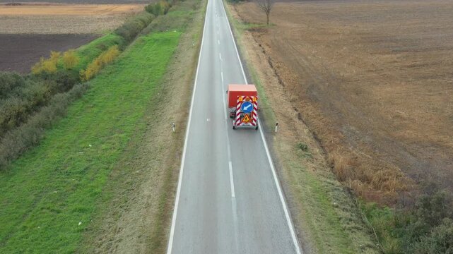 Above top view, dolly move over worker cutting weed among road signs with hand mower, motor signage grass trimmer, edger. Service truck with trailer carry traffic signs for road works