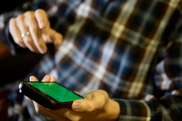 Casual man in plaid shirt using smartphone