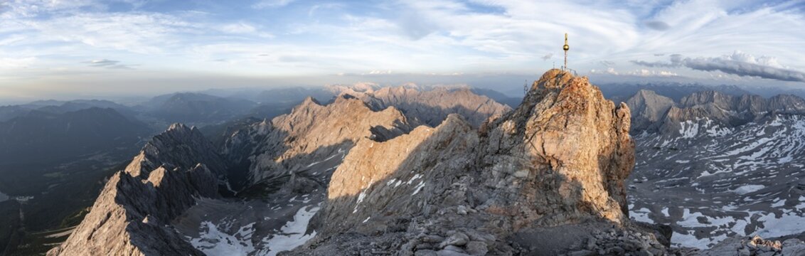 Impressive rocky mountain landscape in the evening light, summit of the Zugspitze with summit cross, steep mountain ridge Jubil&auml;umsgrat and Waxensteinkamm, view into the H&ouml;llental, mountain panorama from the Zugspitze, Wetterstein range, Bavaria, Germany