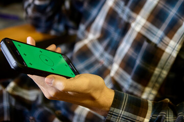 Horizontal closeup of man using smartphone indoors