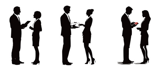 Two pairs of business professionals are interacting in a formal atmosphere. One couple is exchanging documents, while the other is sharing a small item.