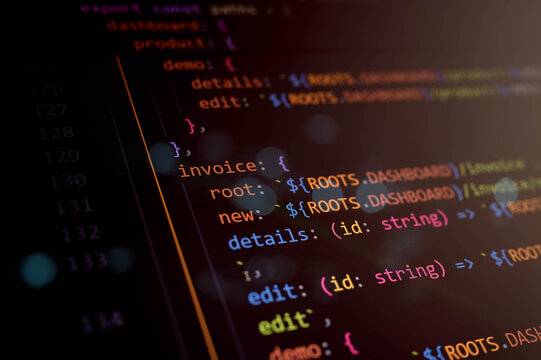 Abstract close-up of generic colorful programming code on a dark screen with soft bokeh, perfect for illustrating software development, coding education, and modern digital technology themes.