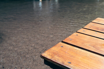 Fototapeta premium Serene water scene, calm surface reflecting light, wooden dock extending into water, ideal for relaxation or contemplation.