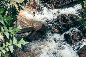Tranquil natural stream flowing over rocks, lush greenery surrounding water, ideal for relaxation and nature themes.
