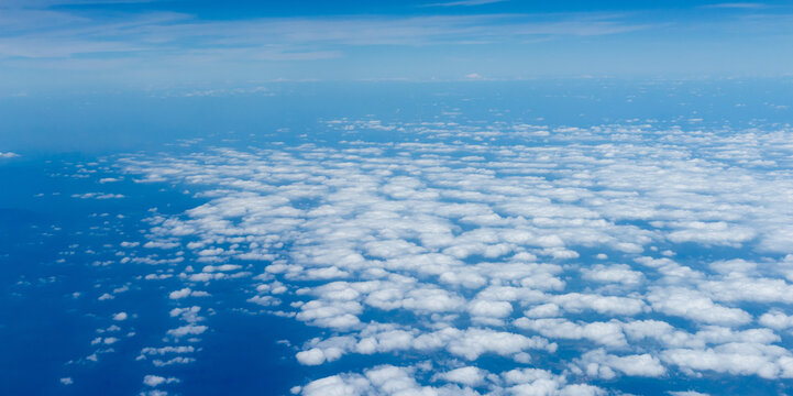 Beautiful landscape view trough window of airplane and cloudless sundown sky behind window of aircraft during flight. blue sky. Flying in the sky and the sea of clouds.