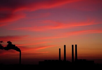 Twilight sky, silhouetted industrial chimneys belching dark smoke,  bleak,  carbon emissions