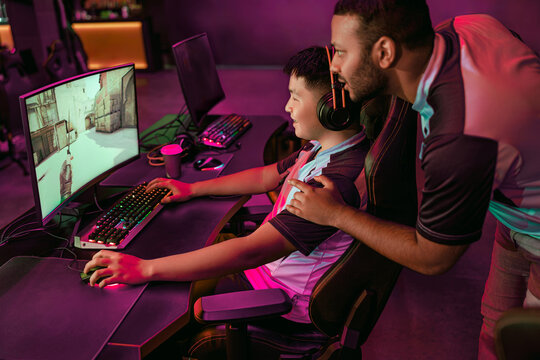 A mentor guiding a gamer in an immersive eSports setting, highlighting teamwork and skill development.