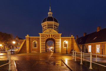 Obraz premium Historic Morspoort city gate illuminated at night in Leiden, Netherlands