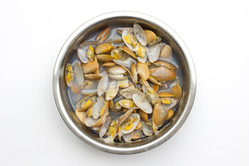 Baby clams inside a large stainless steel bowl. These baby clams are ingredient needed to be cooked in the Asian cuisine recipe.