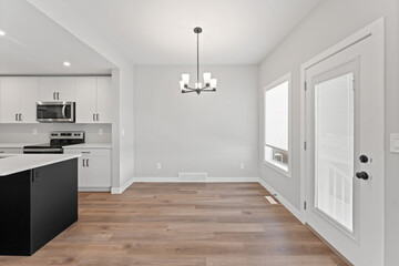 Large, empty dining room with a wooden floor and a black kitchen island