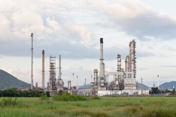 Fototapeta premium Industrial Landscape, oil refinery plant and facility. May called petroleum, production or petrochemical plant. Showcasing details of structure against backdrop of cloudy sky.