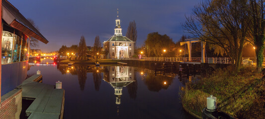 Historic Zijlpoort city gate with reflection at night in Leiden Netherlands