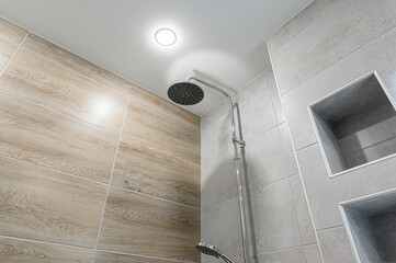 modern bathroom shower area with wood-look tile, gray tile, built-in niches, a chrome showerhead, and recessed lighting