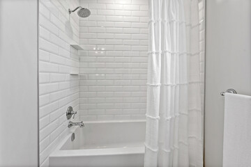 White bathroom with a white shower curtain and a white bathtub