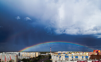Fantastic beautiful rainbow over city buildings after rain