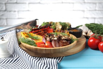 Vegetarian barbecue. Tasty grilled vegetables and mushrooms served on light blue wooden table, closeup