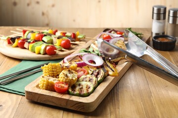 Vegetarian barbecue. Tasty grilled vegetables served on wooden table, closeup