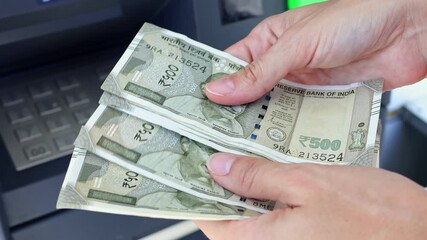 Close up view of woman hands counting Indian rupee banknotes (INR) in ATM. Concept of saving money for retirement, cash settlement, financial goals, success, literacy and income planning in India. - Powered by Adobe