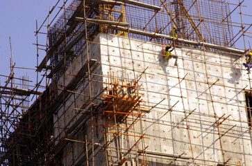 constructing high rise building with exterior scaffolds 
