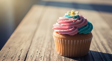 Colorful Swirled Cupcake with Flower Decoration on Wooden Surface in Bright Natural Light