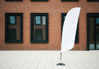 A blank teardrop banner mockup in front of a modern red brick office building a clean and corporate signage presentation for a company