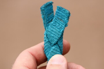 A person holding a piece of yarn in their hand, ideal for crafting or DIY projects