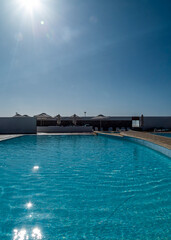 People enjoying a sunny day at a pool.