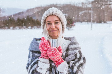 Portrait of happy adult woman in woolen sweater enjoying winter moments