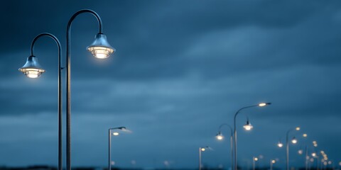 Row of street lights are lit up on a cloudy night