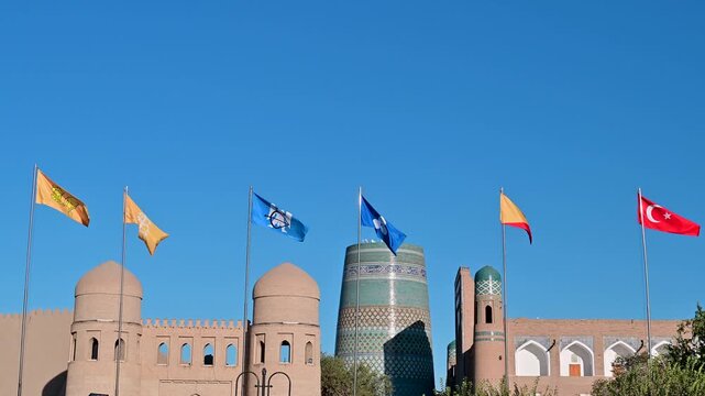 Flags waving in front of the city gates of Khiva, Uzbekistan in slow motion