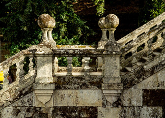 Stone balustrade and staircase in a garden setting.