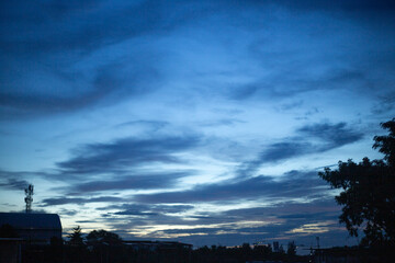 Dark blue sunlight sunset sky background with rain cloud and town building in evening of the day landscape skyscape 