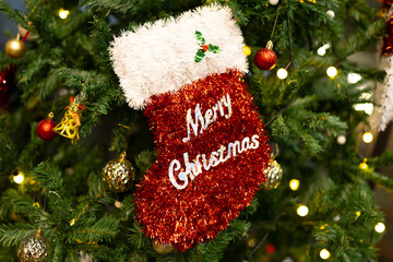 Close up Merry Christmas Red sock on Christmas tree ball bulb decorations background