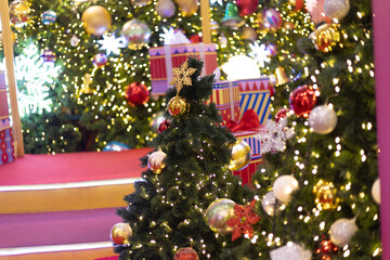 close up multicolor decoration ball with snow star and light bulb on Christmas tree pile tree at night time on holiday snowy xmas theme in december 