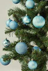 A Christmas tree decorated with a variety of blue ornaments.