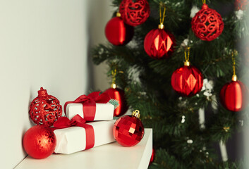 Christmas still life with wrapped gifts and red ornaments.