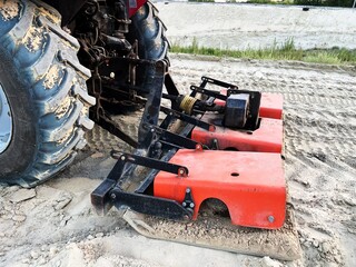 Special equipment for compacting sand compacts sand at a road construction site