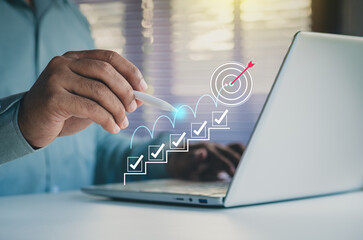 Businessman planning goals with digital checklist and target strategy, success achievement steps,...