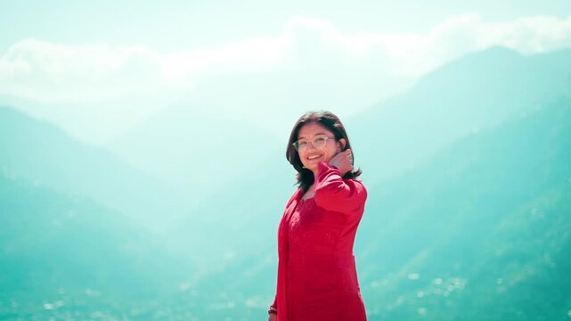 4K Portrait of beautiful Indian woman wearing traditional dress standing against mountain valley in Kullu, Himachal Pradesh, India. Woman wearing salwar suite enjoying vacation. Indian people portrait