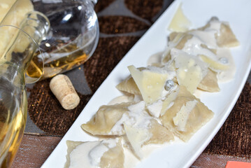 ravioli with crayfish in a white plate on a dark background