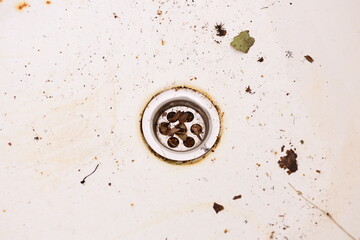 A dirty sink with a bunch of dirt and grime accumulated, suitable for use in scenes related to...