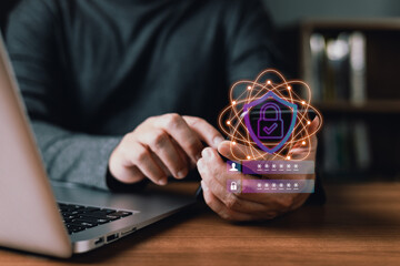 A person holds a smartphone beside a laptop with glowing holographic security icons including a lock,shield,and login credentials,representing cybersecurity,password protection,and digital privacy.