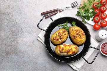 Tasty stuffed baked potatoes served on grey table, flat lay. Space for text